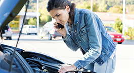 femme qui regarde le moteur de sa voiture