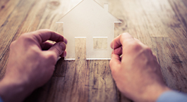 deux mains qui tiennent une petite maison